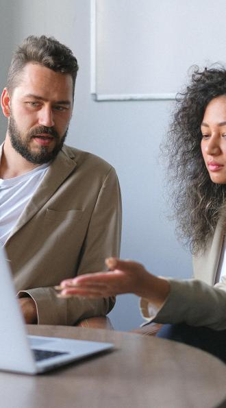 Deux personnes devant un ordinateur se posant la question sur la mise en conformité de leur entreprise